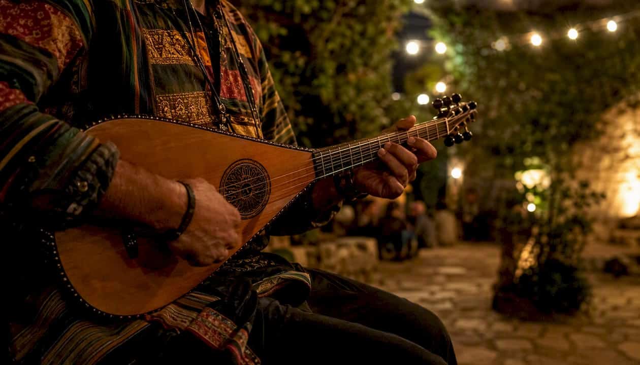 Local musician playing traditional instrument outdoors at night